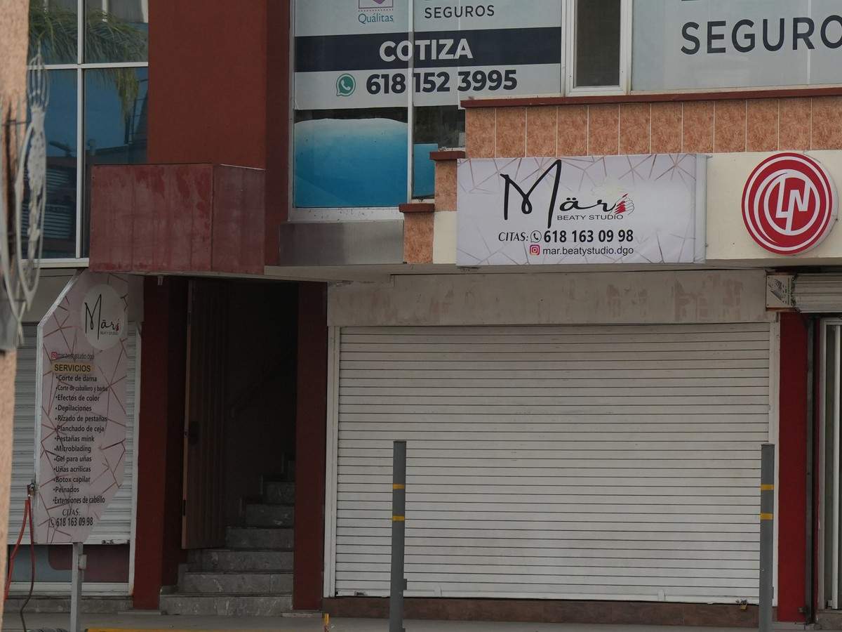 Acceso a las escaleras desde la banqueta, junto a la cortina metálica