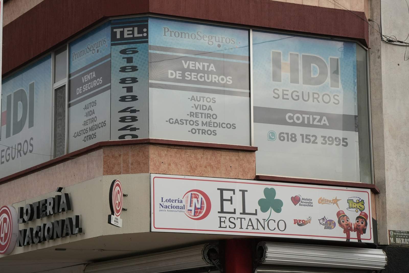 Letreros de PromoSeguros en el primer piso del edificio, sobre los locales de lotería, en Durango